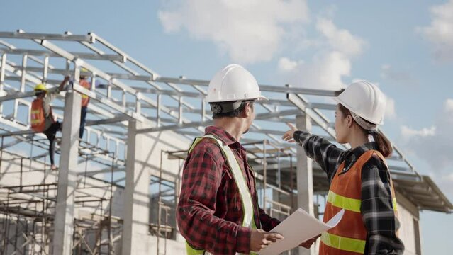 Two architect and client discussing help create plan with blueprint home building at construction site