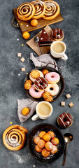 Table with various cookies, donuts, cakes and coffe cups
