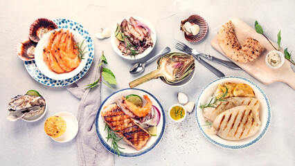 Grilled fish and seafood assortment on light background.