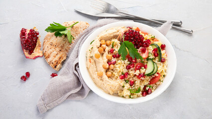 Bulgur and hummus salad on light background.