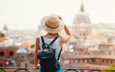 Young attractive smiling girl tourist exploring new city at summer