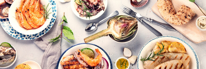 Grilled fish and seafood assortment on light background.