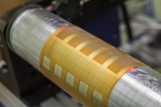 A fragment of the machine for sticking flexo forms on the cylinders of the printing press. Printing equipment. Dust and dirt on equipment parts. Selective focus, film grain