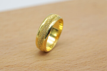 yellow gold ring placed on a wooden floor
