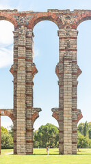 Tourist under stone arches of Miraculous aqueduct