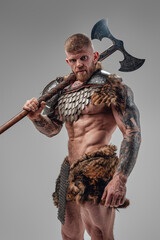 Formidable viking with strong body holding two handed axe