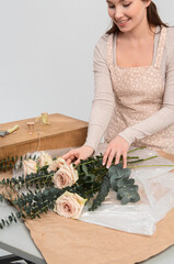 Portrait florist, wich hands holding a fresh flower, making a bouquet or flower arrangement, florist master class or workshop. Concept of reciprocated love and dating, isolated on white.