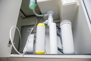 Installing water filter filtration in house in white kitchen