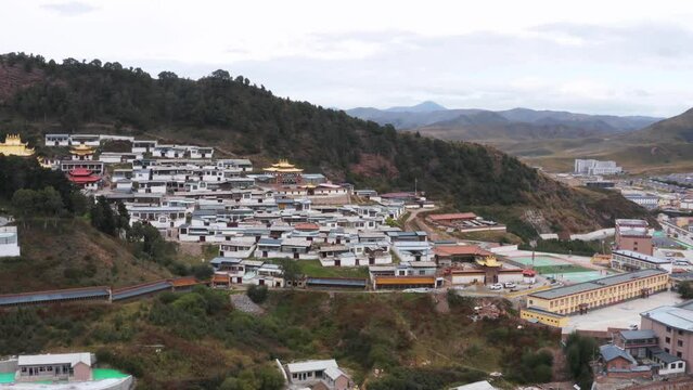 Small mountainous Tibetan town with gold temples and traditional houses