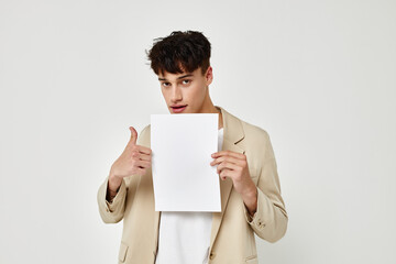 portrait of a young man posing with a white sheet of paper isolated background unaltered