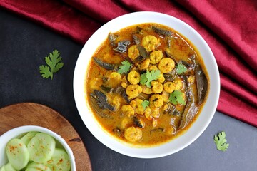 Tangy and spicy Shrimp curry. Tiny prawns curry made using dried mango and Indian spices. garnished with coriander and served with cucumber slices. Copy space.