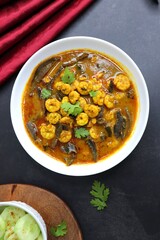 Tangy and spicy Shrimp curry. Tiny prawns curry made using dried mango and Indian spices. garnished with coriander and served with cucumber slices. Copy space.