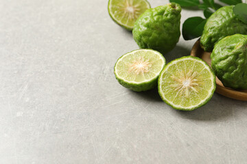 Fresh ripe bergamot fruits on light grey table, space for text