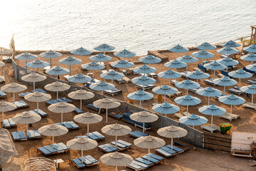 A beach club in morning with no people and blue and beach umbrellas