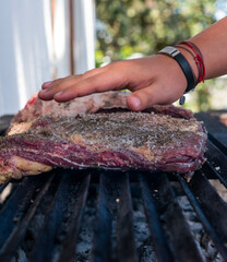 costillar de res completo en asador. 

costillas de res asadas al carbón 

costillas de res levantado  y girándolo con pinza.

Costilla de Res completa a fuego directo
