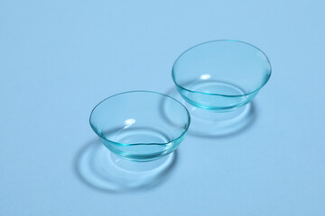 Pair of contact lenses on light blue background