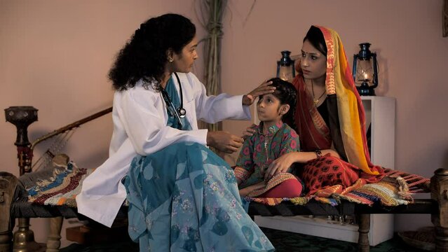 A Worried Mother Of An Indian Village Consulting A Doctor For Her Child's Illness. A Lady Doctor Checking The Little Girl - Rural Healthcare Service  Female Doctor In Village  Medical Facilities In...