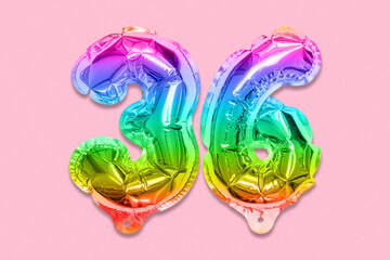 Rainbow foil balloon number, digit thirty six on a pink background. Birthday greeting card with inscription 36. Top view. Numerical digit. Celebration event, template.