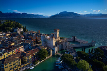 Fototapeta na wymiar Aerial view of Sirmione. The flag of Italy on the main tower of the castle. Sirmione Castle, Lake Garda, Italy.