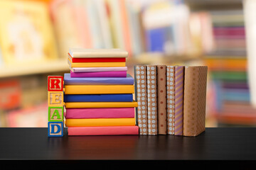 Stack of books on wooden table against blurred background