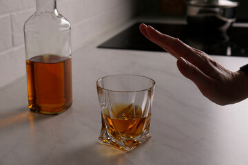 Woman refusing to drink whiskey indoors, closeup. Alcohol addiction treatment