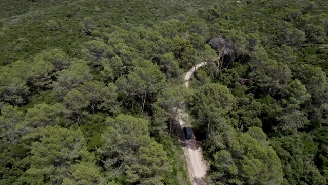 Mountain road with work van ascending the hill, Aerial tilt up reveal shot