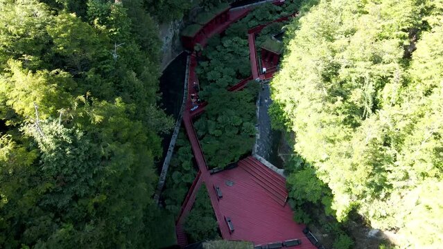 Aerial dolly out of runway and pools in Termas Geometricas hot spring complex, surrounded by forest, Co&ntilde;aripe, Chile