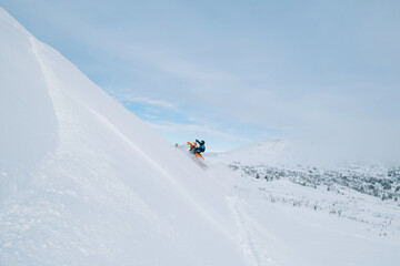 Snowbike rider in mountain valley in beautiful snow powder. Modify dirt bike with snow splashes and trail. Snowmobile sport riding, winter sunny day