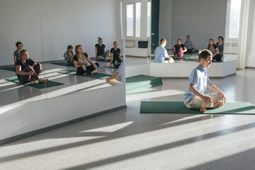 Yoga teacher man giving lesson to female group in yoga studio