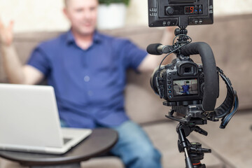 A man in a blue shirt emotionally leads his blog telling a story on camera