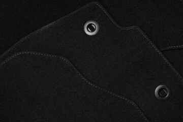 Black car floor carpets as background, closeup view