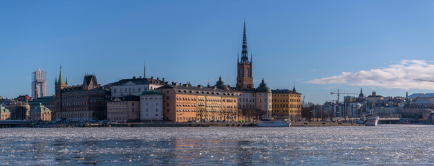 The island Riddarholmen with court houses and the church Riddarholmskyrkan at the bay Riddarholmsfjärden with ice floes a sunny winter day in Stockholm