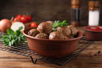 Tasty cooked meatballs with parsley on wooden table