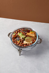 Appetizers set on luxury plate with hazelnut. Creative platter of appetizers from inspirational chef. Salmon cheesecake, fish tartar, pastrami crocket, liver pate, baked mini-paprika