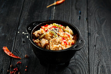 Chicken fried rice on wok. Asian food - fried rice with vegetables, egg and chicken on dark table. Wok menu on black wood background. Traditional chinese food.