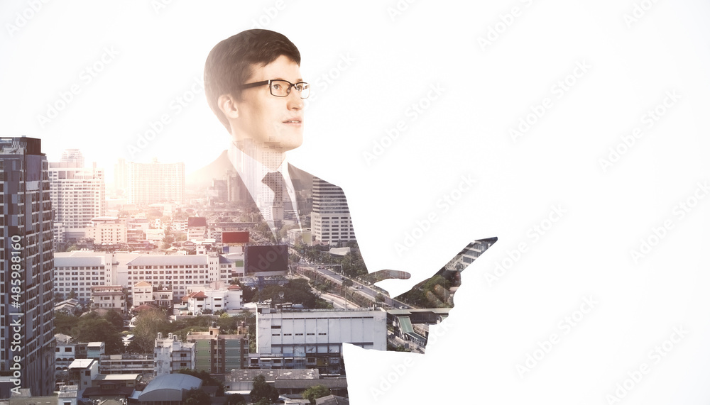 Poster portrait of attractive thoughtful european business man using smartphone or tablet on bright city ba