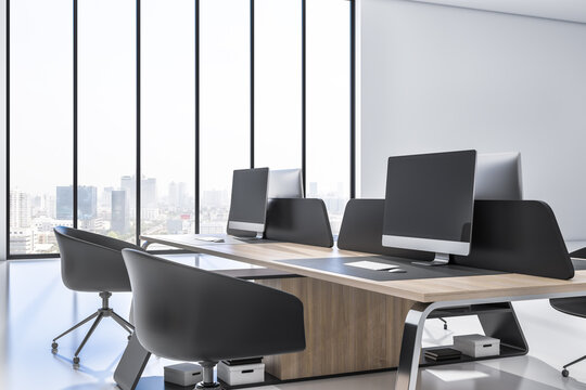 Modern coworking office interior with wooden furniture, equipment, computer monitors and window with blurry city view and daylight. 3D Rendering.