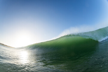 huge wave breaking close up with sunset in the background