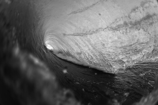 moody black and white photo of a crashing wave
