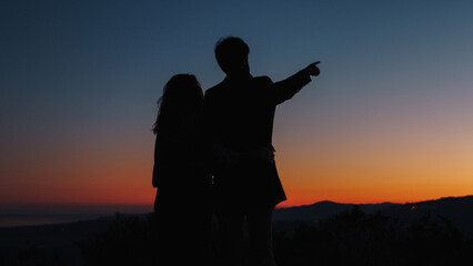 Fototapeta na wymiar Silhouette of boy and girl point to the stars in the sky 