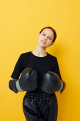 young woman black boxing gloves posing yellow background sport