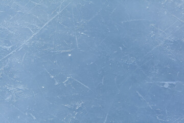 Empty ice rink with skate marks after the session outdoor. skating ice rink texture covered with snow in daylight. Close up of blue ice rink floor, copy space