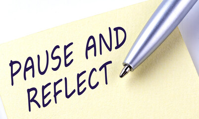 Sticky Note Message PAUSE AND REFLECT with pen on white background