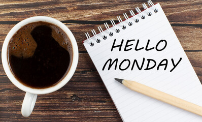 HELLO MONDAY text on notebook with coffee on wooden background