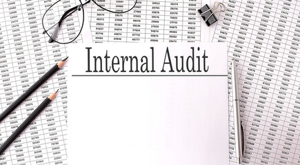 Papers with text INTERNAL AUDIT on table, business concept.