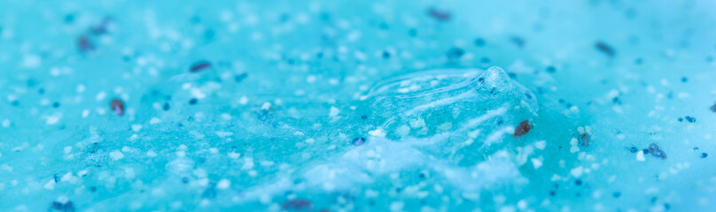 Body scrub close-up of blue color, particles of exfoliating ingredients, bubbles. Gel for cleansing...
