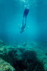 Boy in diving flipper swimming undersea