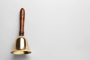 Fototapeta na wymiar Golden school bell with wooden handle on grey background, top view. Space for text