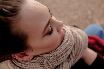 portrait of beatuful woman with over weght body walking in the beach, The plus size model wearing jeans, the warm knitted blanket and sweater. the wind in the bich have fun with hairs