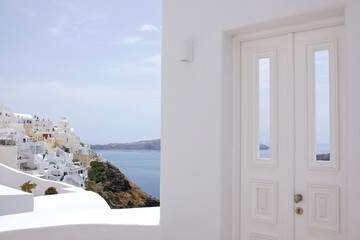 Fototapeta premium A beautiful whitewashed door with a view to the aegean sea and the blue sky in Santorini Greece